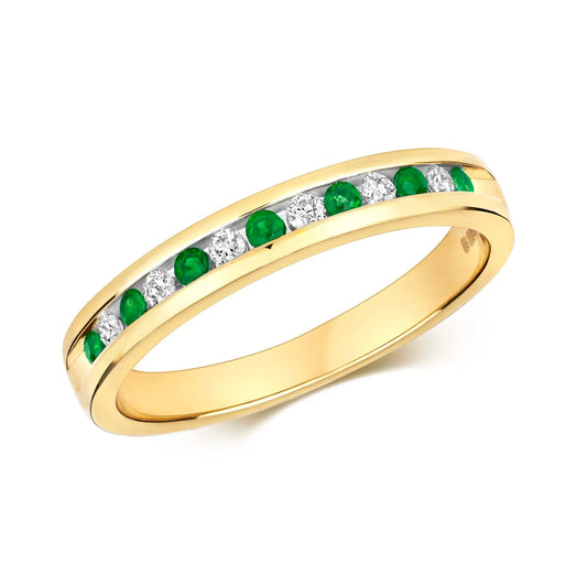 emerald and diamond gold band ring on white background