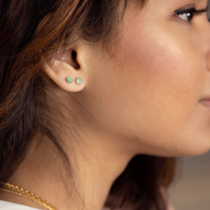 model wearing chrysoprase studs in gold