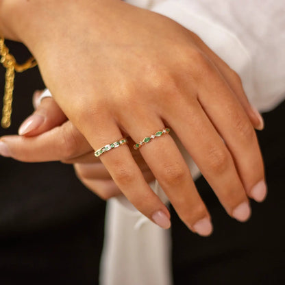 model wearing emerald and diamond gold ring