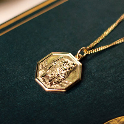 octagonal solid gold st christopher necklace with raised relief on dark green leather