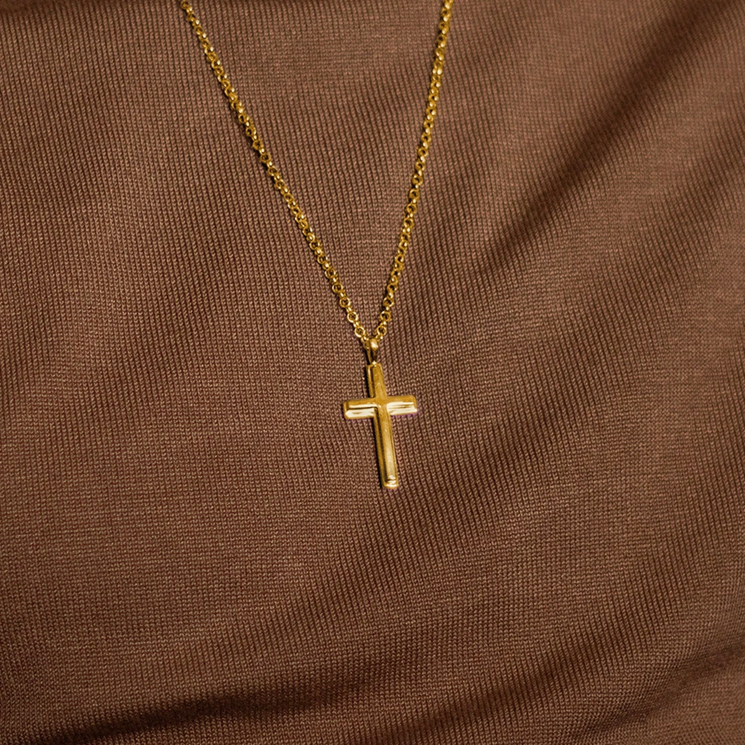 large gold cross necklace, sturdy gold belcher chain, high polish finish, bevelled edges, religious Christian pendant for men and women, brown fabric background