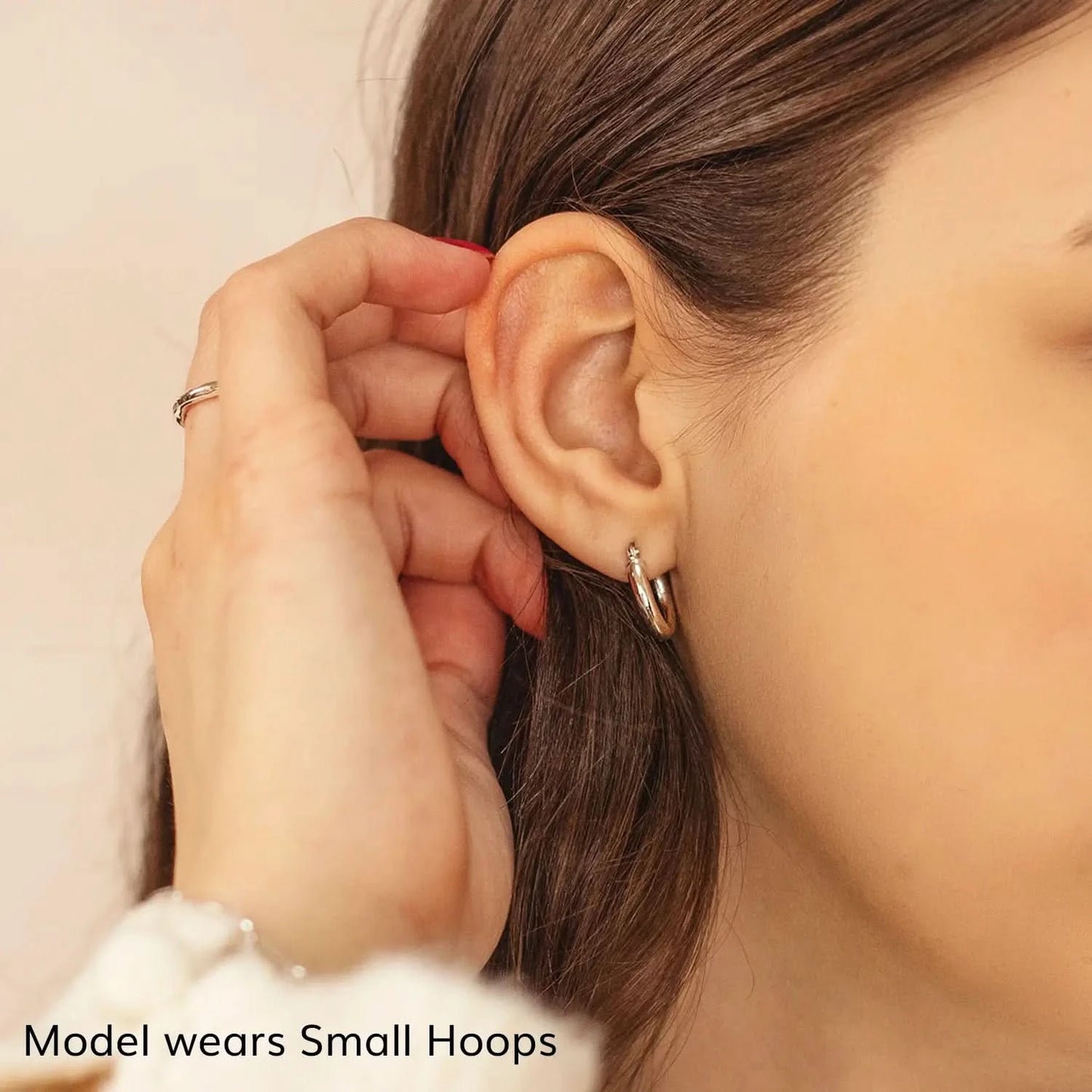 woman wearing chunky white gold hoop earrings, thick round hoop earrings, shiny white gold hoops small